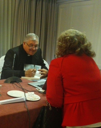 El padre Juan Solana L.C. firmando libros 